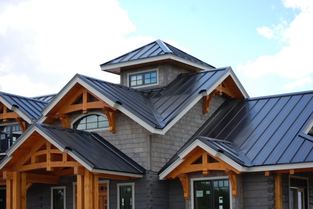 Timber-frame home with dark standing seam metal roofing