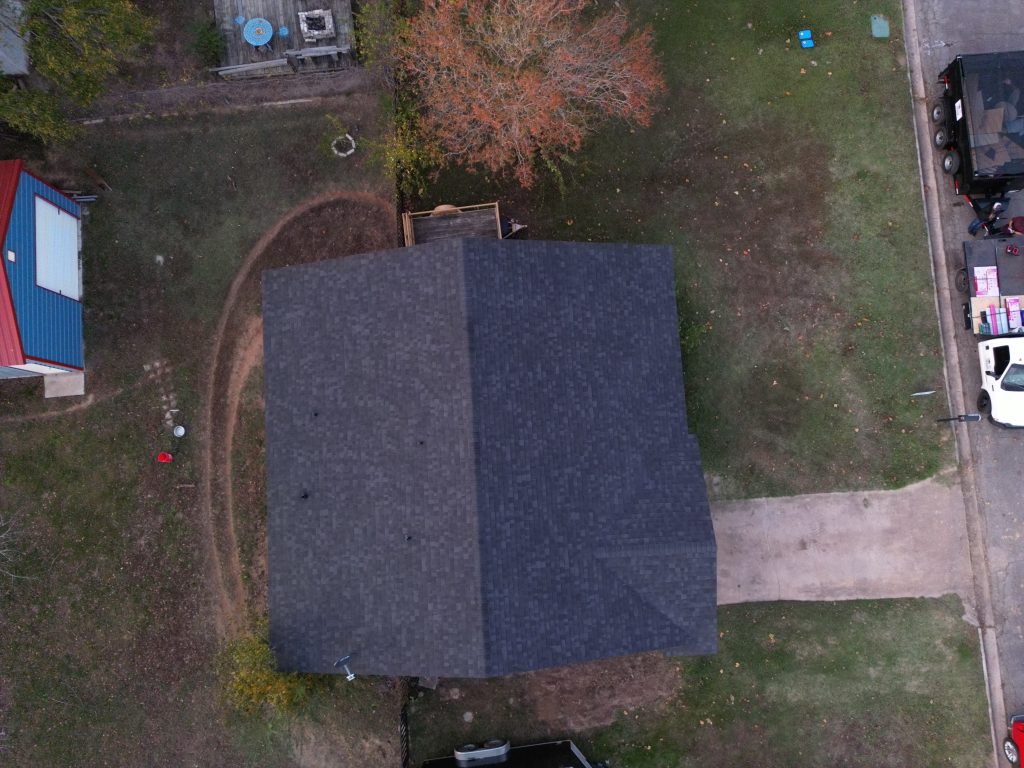 Aerial view of a dark shingle roof on a ranch house with a circular driveway