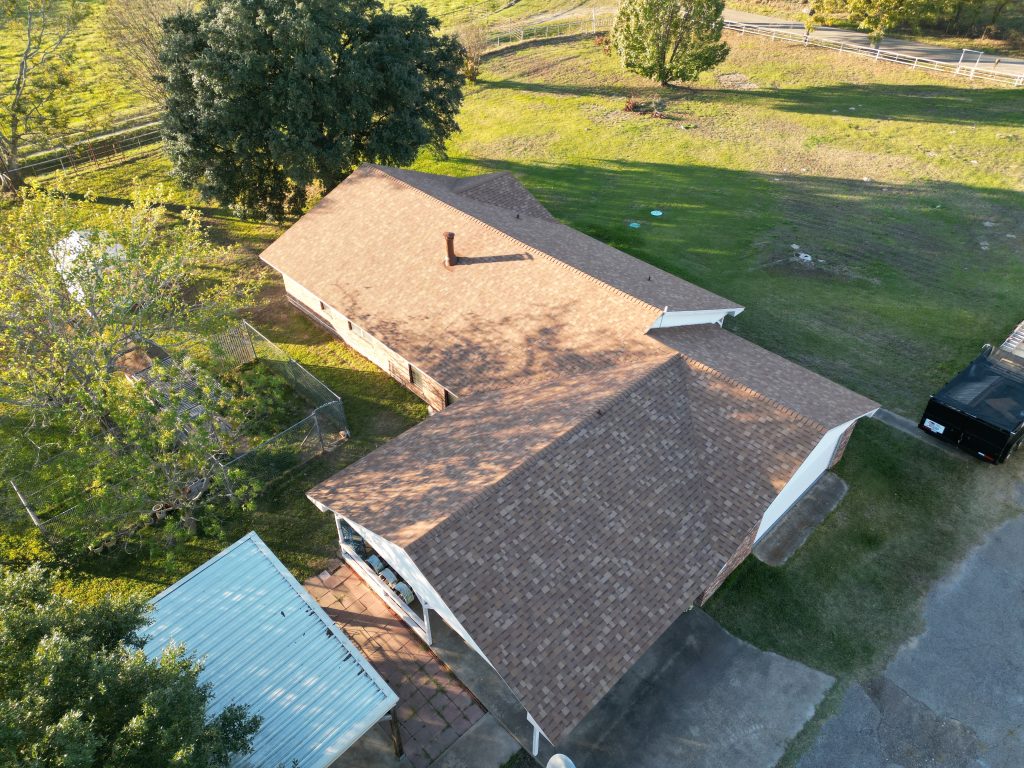 Aerial view of a tan shingle roof partway through a replacement, with a section still open