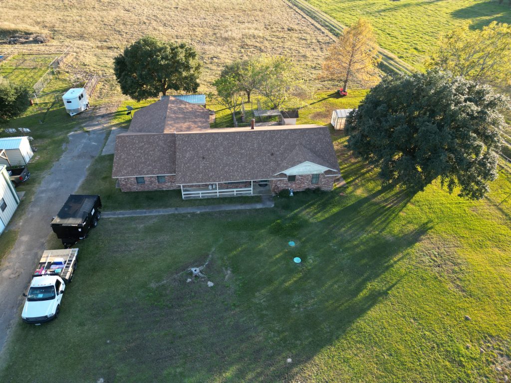 Shingle Roofing in Mount Pleasant, TX 5 Aerial view of a brown shingle roof on a long brick ranch house