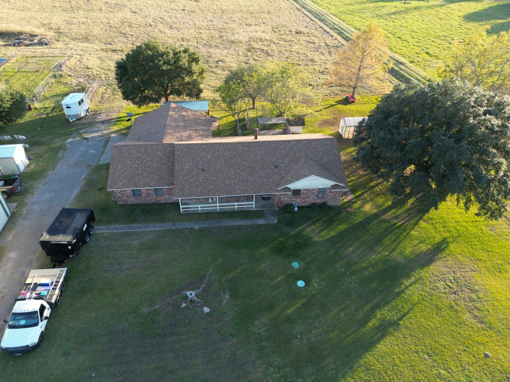 Shingle Roofing in Mount Pleasant, TX 6 Aerial view of a completed brown shingle roof on a brick ranch house