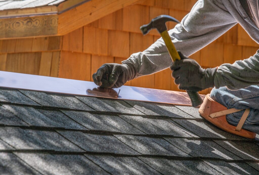 Roofer installing new flashing during a roof repair